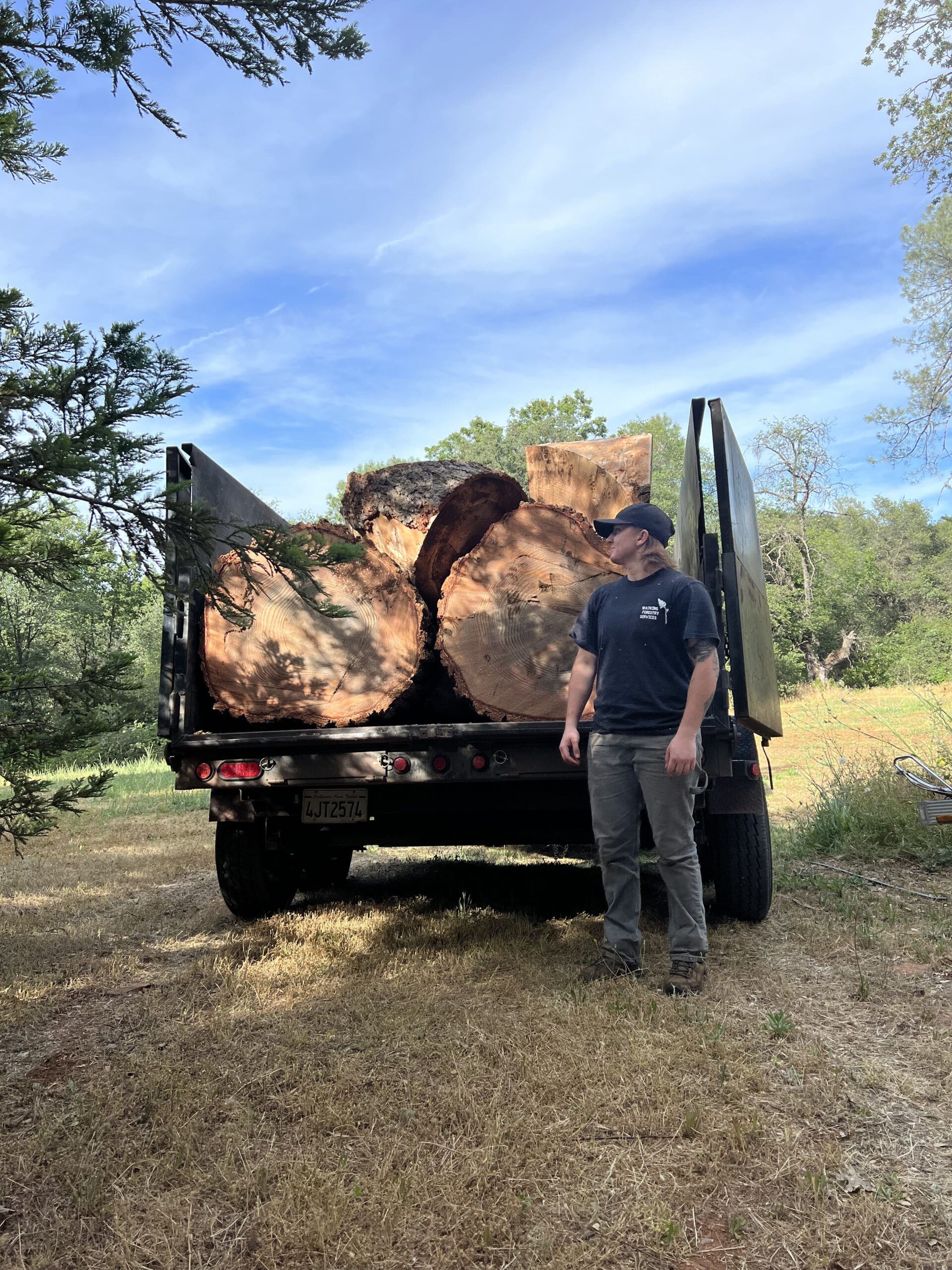 A Watkins crew member with a truck bed of oak rounds